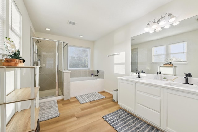 full bathroom featuring a sink, a shower stall, a bath, and visible vents