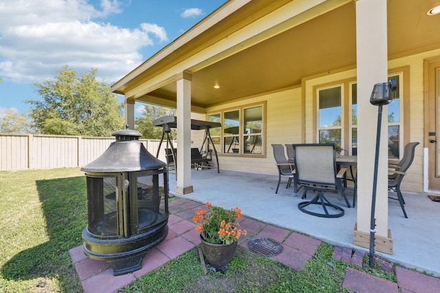 view of patio featuring fence, outdoor dining area, and an outdoor fire pit