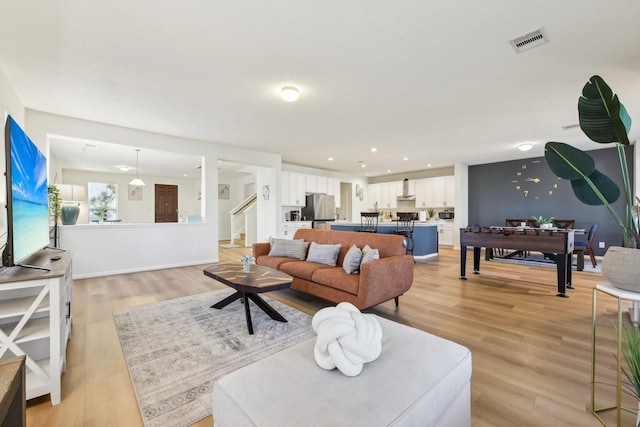 living area with stairs, recessed lighting, visible vents, and light wood-type flooring