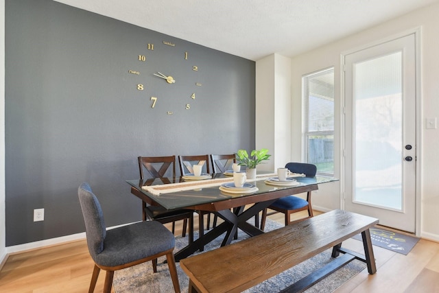dining room with baseboards and light wood-style floors