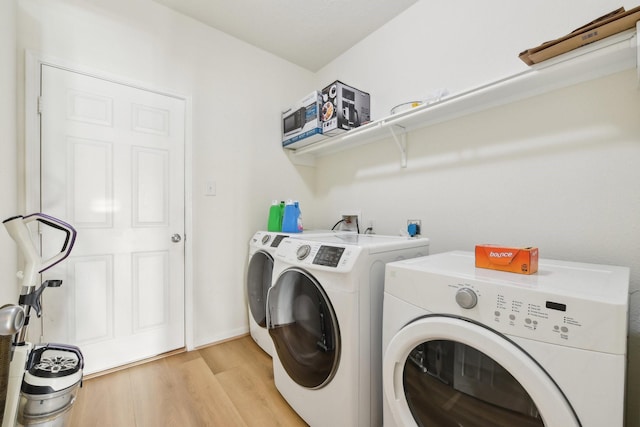 laundry room with laundry area, light wood finished floors, and washer and dryer