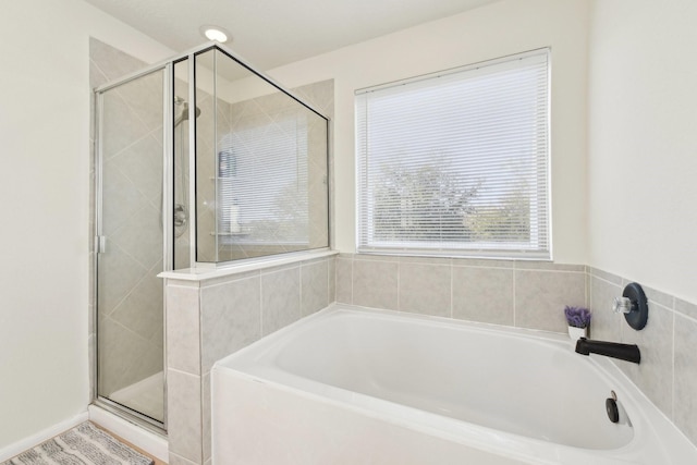 bathroom with a shower stall and a bath