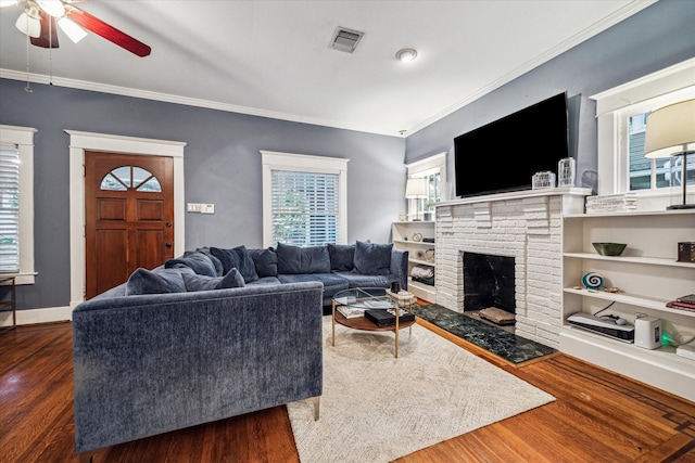 living room featuring visible vents, a ceiling fan, crown molding, and wood finished floors