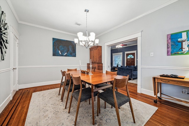 dining space featuring an inviting chandelier, baseboards, wood finished floors, visible vents, and ornamental molding