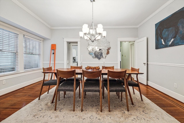 dining space featuring an inviting chandelier, baseboards, crown molding, and wood finished floors