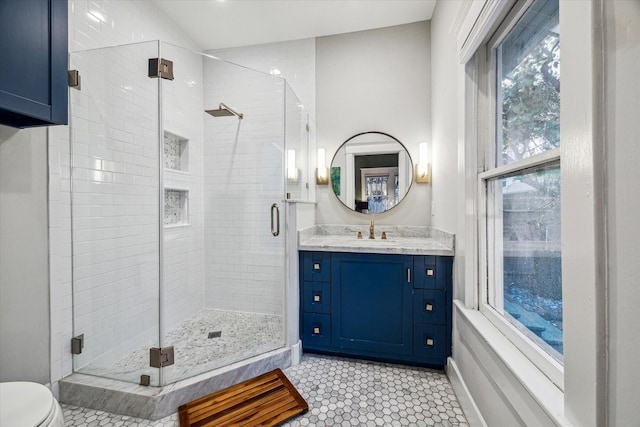 full bath with vanity, a shower stall, and toilet