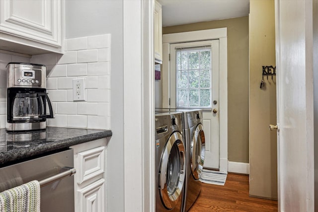 laundry area featuring baseboards, laundry area, dark wood finished floors, and washer and dryer