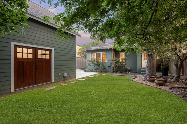 yard at dusk featuring fence