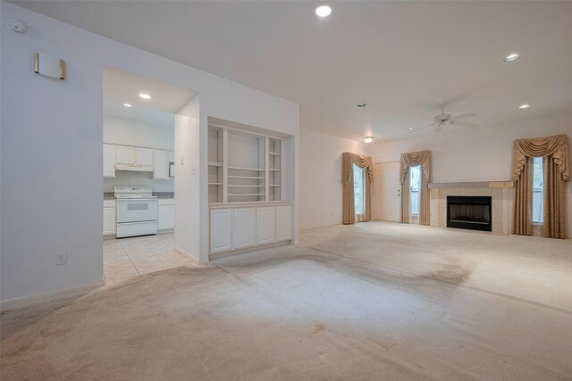 unfurnished living room featuring recessed lighting, ceiling fan, light carpet, and a wealth of natural light
