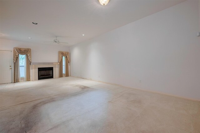 unfurnished living room featuring a tiled fireplace, ceiling fan, carpet, and recessed lighting
