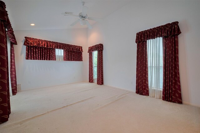 carpeted spare room featuring ceiling fan and lofted ceiling