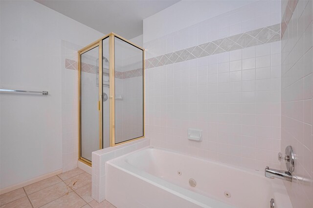 full bath with baseboards, a tub with jets, a shower stall, and tile patterned floors