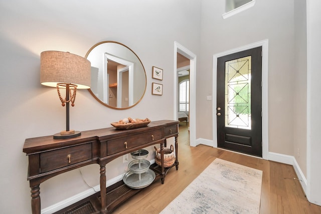 foyer entrance featuring baseboards and wood finished floors