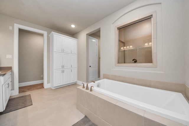 bathroom with vanity, a tile shower, a garden tub, and recessed lighting