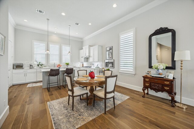 dining area with crown molding, recessed lighting, wood finished floors, a toaster, and visible vents