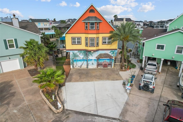 view of front of home featuring fence, driveway, and a residential view