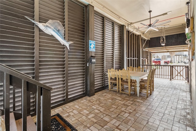dining area featuring ceiling fan and brick patterned floor