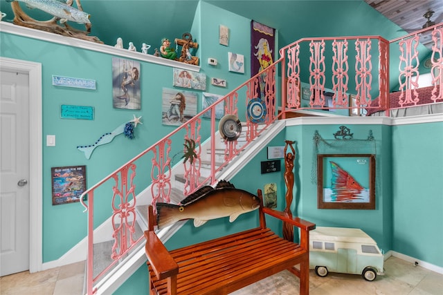 stairway with baseboards and tile patterned floors