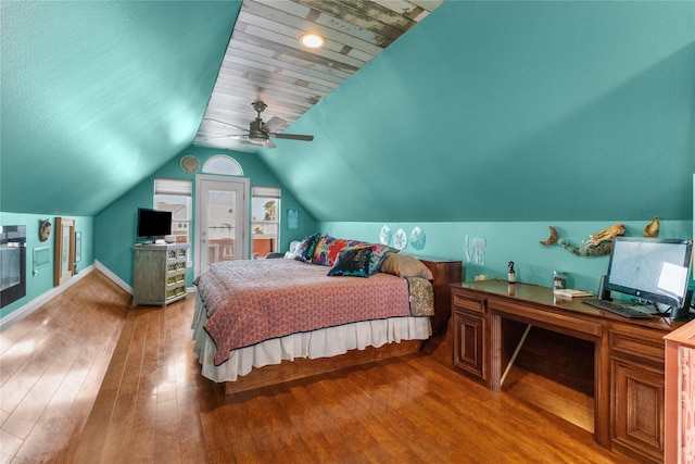 bedroom featuring wood-type flooring, a ceiling fan, baseboards, and lofted ceiling