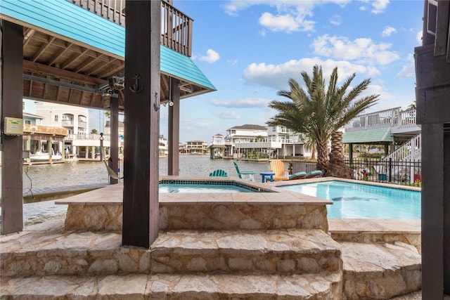 pool with a water view and an in ground hot tub