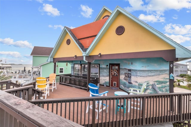 rear view of property featuring stucco siding and a deck