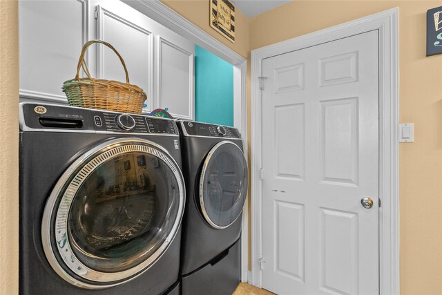 laundry area featuring washing machine and clothes dryer and cabinet space