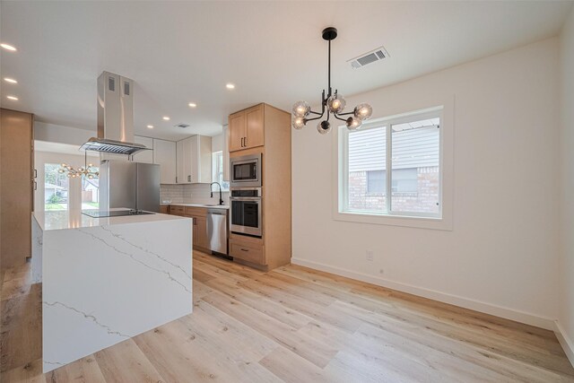 kitchen with an inviting chandelier, visible vents, island exhaust hood, appliances with stainless steel finishes, and a wealth of natural light