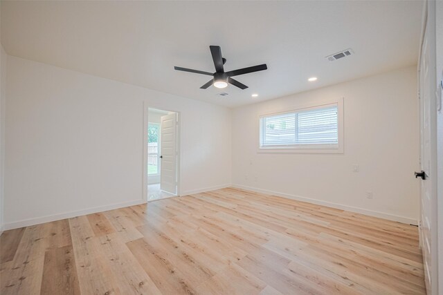 spare room with plenty of natural light, light wood finished floors, and visible vents