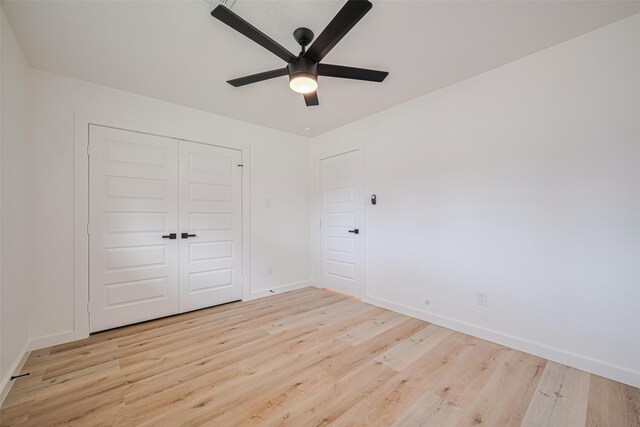 unfurnished bedroom with baseboards, ceiling fan, a closet, and light wood finished floors