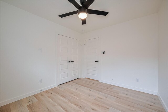 unfurnished bedroom featuring a ceiling fan, baseboards, and light wood-style floors