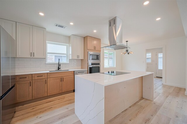 kitchen with island range hood, a center island, tasteful backsplash, a sink, and stainless steel appliances