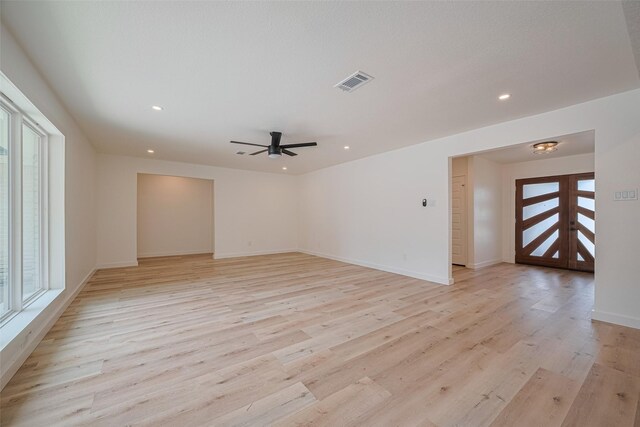 unfurnished living room featuring a healthy amount of sunlight, ceiling fan, light wood-style flooring, and visible vents