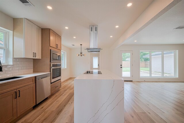 kitchen featuring a center island, stainless steel appliances, light wood-style flooring, and visible vents