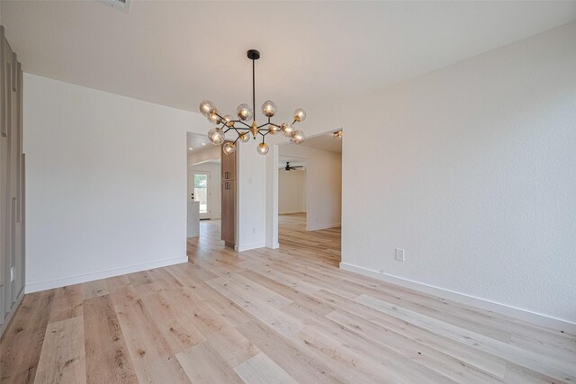 unfurnished dining area featuring baseboards, a chandelier, and light wood-style floors