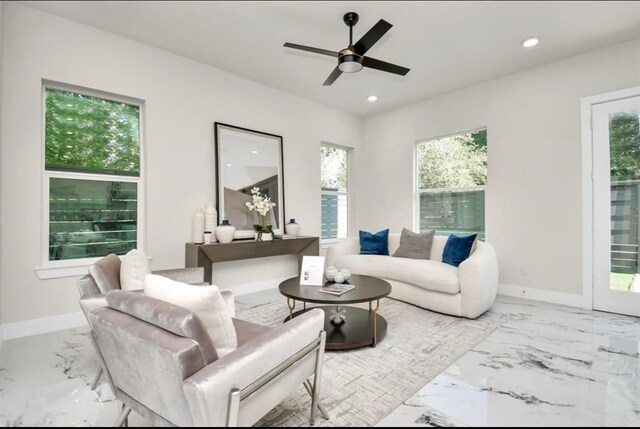 living area with plenty of natural light, a ceiling fan, marble finish floor, and recessed lighting