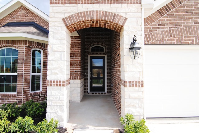 view of exterior entry featuring brick siding and stone siding