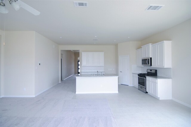 kitchen with white cabinets, stainless steel appliances, visible vents, and decorative backsplash