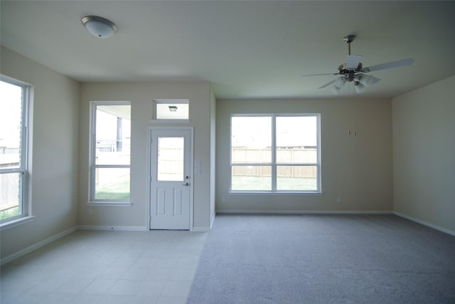 interior space with baseboards and a ceiling fan