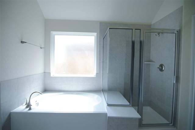 full bathroom featuring a garden tub and a shower stall