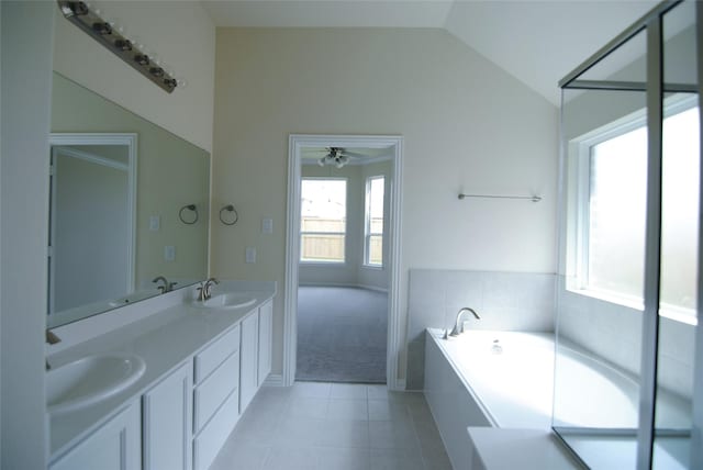 full bathroom featuring tile patterned flooring, a sink, a garden tub, and lofted ceiling