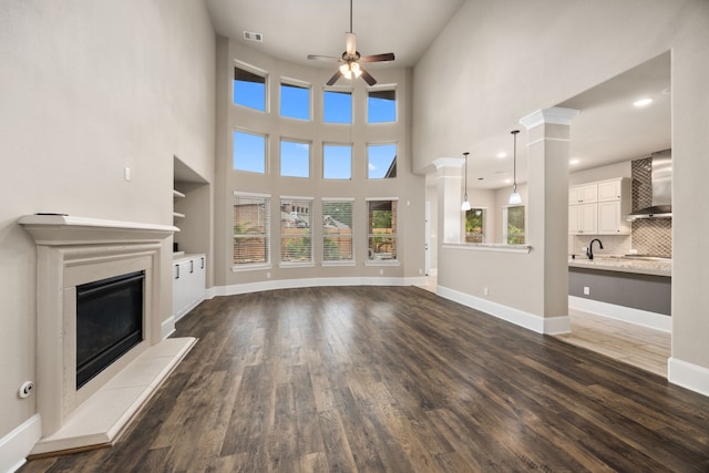 25211 Birchwood Springs Ave, Porter, TX 77365 - unfurnished living room featuring ceiling fan, a glass covered fireplace, dark wood finished floors, baseboards, and visible vents