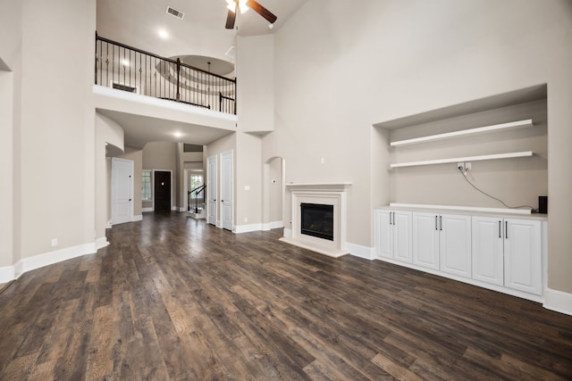25211 Birchwood Springs Ave, Porter, TX 77365 - unfurnished living room featuring a glass covered fireplace, ceiling fan, dark wood-style floors, and visible vents