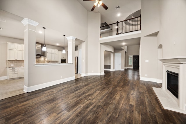 25211 Birchwood Springs Ave, Porter, TX 77365 - unfurnished living room featuring ceiling fan, a glass covered fireplace, baseboards, wood finished floors, and visible vents