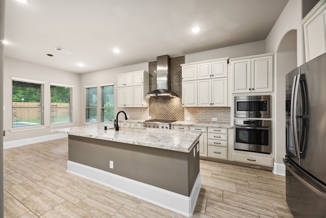 25211 Birchwood Springs Ave, Porter, TX 77365 - kitchen featuring tasteful backsplash, a sink, light stone counters, stainless steel appliances, and wall chimney exhaust hood