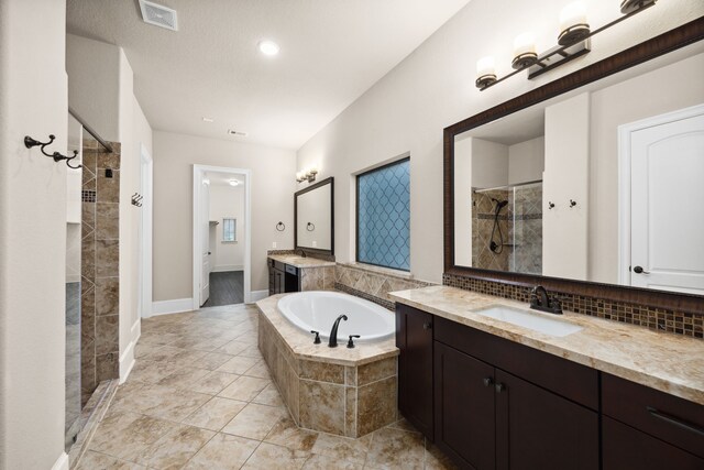 25211 Birchwood Springs Ave, Porter, TX 77365 - bathroom featuring a sink, two vanities, a shower stall, visible vents, and a garden tub