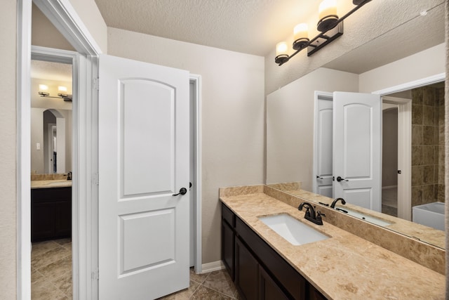 25211 Birchwood Springs Ave, Porter, TX 77365 - bathroom featuring vanity, a textured ceiling, tile patterned floors, and a tub to relax in