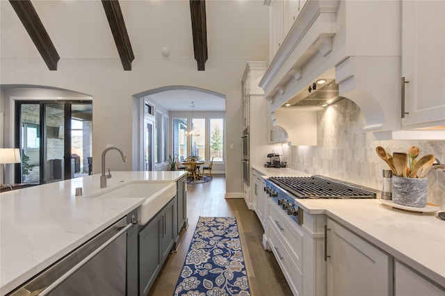 kitchen featuring a sink, stainless steel gas stovetop, dark wood finished floors, and white cabinetry