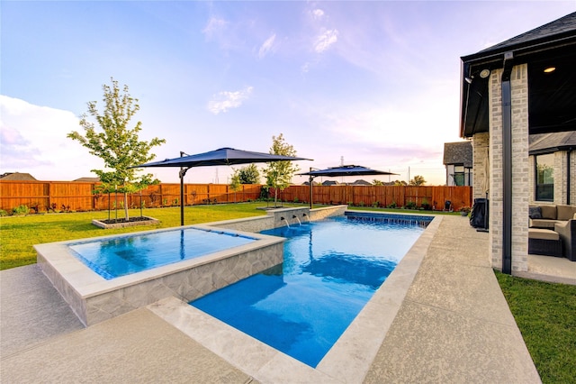 pool at dusk with a lawn, a fenced in pool, a fenced backyard, and a patio