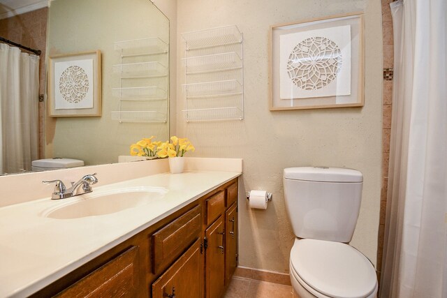 bathroom featuring vanity, tile patterned flooring, and toilet