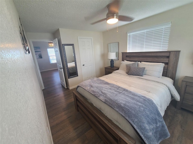 4222 Mason Dr, Galveston, TX 77554 - bedroom with a textured ceiling, baseboards, a ceiling fan, and dark wood finished floors